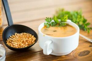 Cooked dried pea puree soup with mushrooms in a bowl . photo