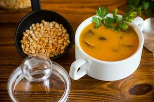 Cooked dried pea puree soup with mushrooms in a bowl . photo