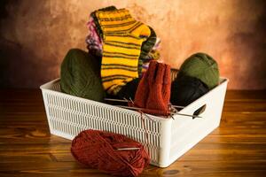 Colored yarn, knitting needles and other items for hand knitting in a box . photo