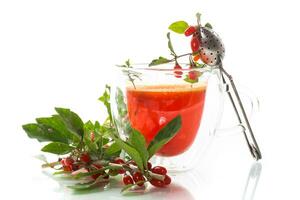 Prepared hot drink from ripe goji berries in a glass cup photo