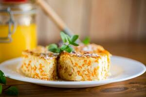 Cooked cottage cheese casserole with pieces of pumpkin inside. photo