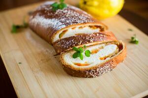 Cooked sweet pie with quince and pumpkin inside, yeast dough roll. photo