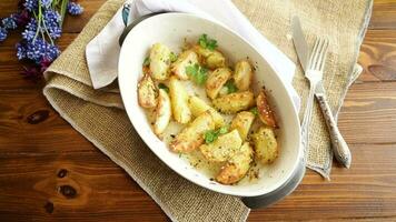 potatoes baked with sesame seeds, herbs and spices in the oven in a ceramic form. video