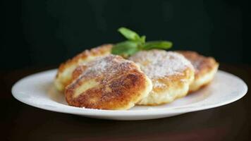 sucré cuit gâteaux au fromage dans en poudre sucre dans une assiette sur le tableau. video