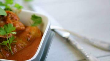 Traditional stuffed cabbage with minced meat and rice, served in a tomato sauce on a wooden table . video