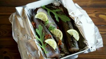 Raw fish with seasonings and spices prepared for baking in foil, in a ceramic form. video