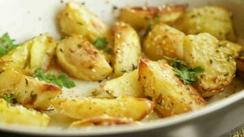 aardappelen gebakken met sesam zaden, kruiden en specerijen in de oven in een keramisch het formulier. video