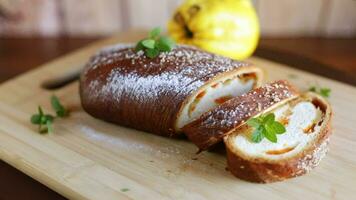 Cooked sweet pie with quince and pumpkin inside, yeast dough roll, on a wooden table. video