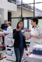 Young asian woman returning wrong vitamin package in drugstore, asking pharmaceutical consultant to exchange dietary supplements box. Customer showing chemist multivitamin components on bottle photo