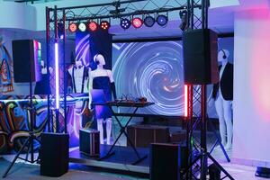Dj equipment on stage for electronic music live performance in nightclub. Musician controller for sound mixing, speakers and spotlights for party discotheque in club with no people photo