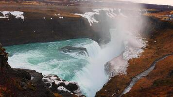 Gullfoss waterfall in iceland circa March 2023 with spectacular water stream and wild reykjavik scenery. Cascade with river flowing near snowy cliffs, scandinavian landscapes. Handheld shot. photo