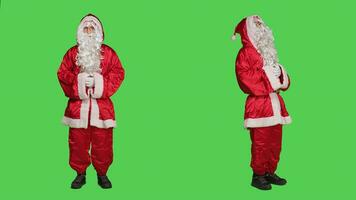 Santo mella persona en festivo rojo traje riendo terminado lleno cuerpo pantalla verde, posando como estacional principal personaje durante invierno celebracion. adulto retratar Papa Noel claus con blanco barba y sombrero. foto