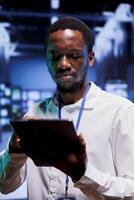 Skilled technician in server hub providing dedicated VPN servers able to deliver enhanced security, encrypted sensitive data, online anonymity, and fast speed bandwidth to users photo