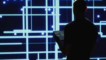 Man engineer verifying big data AI brain used for deep learning and machine learning, artificial intelligence development. Modern cyber security research on tablet, system engineering. Handheld shot. photo