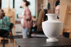 Still life drawing lessons. Ceramic vase standing on table in art room classroom, group of people learning to draw in class, attending creative workshop to learn new skills and boost creativity photo