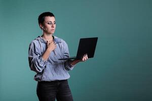 Confident person holding laptop computer discussing financial stratgey with remote team during online videocall meeting conference. Caucasian female looking at device webcam during videoconference photo