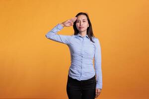 filipino patriota mujer haciendo militar saludo con mano terminado frente, publicidad honor y confiable el respeto en frente de cámara. atractivo joven adulto demostración Ejército soldado Hola gesto en estudio. foto