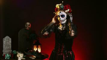 Female model listening to music on audio headset, using headphones to enjoy mp3 song over black background. Creepy horror woman using headphones on holy dios de los muertos tradition. photo