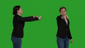 Close up of company worker doing thumbs down sign in studio, showing dislike and negative gesture. Businesswoman with office suit expressing disapproval and disagreement on camera. photo