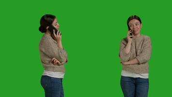 Close up of caucasian woman talking on smartphone line call, using mobile phone line to chat over full body greenscreen. Young cheerful person using telephone to talk to people in studio. photo