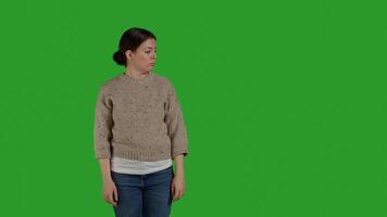 Front view of person showing refusal and pushing thing aside, expressing rejection and denial looking discontent. Female model acting displeased moving object, standing over greenscreen. photo