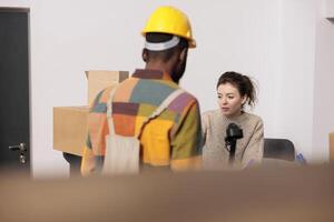 Warehouse employees discussing merchandise inventory report, working at products quality control in storehouse. Diverse team checking online orders preparing customers packages in storage room photo