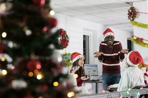 diverso corporativo equipo disfrutando hora gastado juntos en festivo decorado oficina durante fiesta estación. negocio personal sensación Navidad espíritu ánimo, teniendo relajante charla en Navidad adornar espacio de trabajo foto