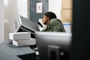 Stockroom supervisor analyzing metallic box, preparing customers orders in warehouse. Storage room manager working at products delivery during merchandise inventory in storehouse photo