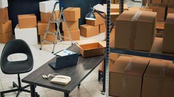 Small business warehouse filled with merchandise to ship to customers, products in cardboard packages used for startup development. Empty storage room space with carton boxes and supplies. photo