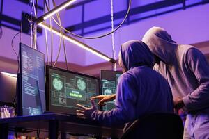 Hackers celebrating successful hacking attempt and getting access granted to database sensitive data. Happy criminals breaking computer network system using malicious software photo