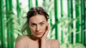 Natural gentle girl advertising shampoo and hair products, feeling beautiful and healthy in new bodycare and self love ad campaign. Beautiful sensual woman posing over bamboo background. photo