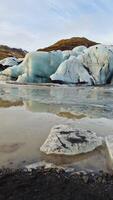 enorme hielo rocas creando vatnajokull glaciar con diamante conformado en islandés región, congelado paisaje y naturaleza. natural ártico agrietado hielo fragmentos flotante en lago, impresionante icebergs foto