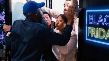 Diverse shoppers argue with security guard, waiting for black friday deals outside of department store. Crazy anxious clients being impatient in front of shopping center entrance. photo