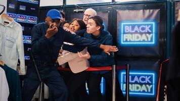 Black friday shoppers argue at entrance to catch promotional prices on clearance items, angry people eager to start shopping. Mall customers pushing security man, asking him to open store. photo