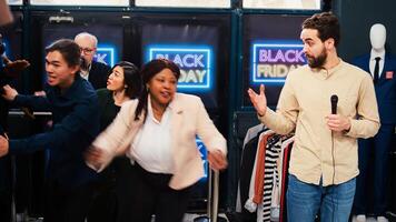 News reporter broadcast live scenes from department store during black friday sales, transmitting reportage for television and media. Journalist using microphone in busy shopping center. photo