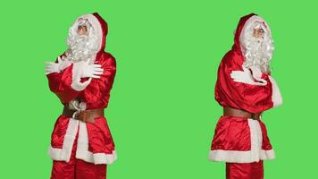 Santa claus character winter celebration on greenscreen backdrop, positive confident person in traditional festive costume with hat and beard. Young man spreading holiday spirit. photo