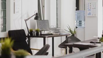 Professional department office with workstation desks, empty open space filled with corporation equipment and pcs. Modern startup agency workspace in boardroom coworking space. photo