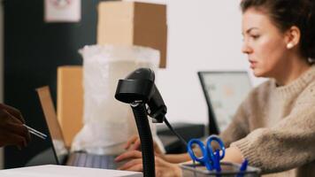 Two employees packing goods in boxes, preparing orders for retail store shipment and distribution. Team of diverse people working on shpping merchandise, verifying stock inventory. photo