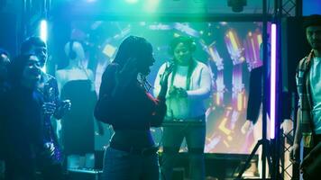 joven personas improvisar danza batalla y ir de fiesta a Club nocturno, teniendo divertido con breakdance batalla a espectáculo apagado habilidades. grupo de amigos disfrutando danza fiesta en moderno discoteca. trípode disparo. foto