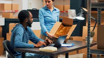 Diverse employees shipping storage products from warehouse, looking at merchandise in boxes before sending package order. Checking inventory and stock, working on distribution logistics. photo