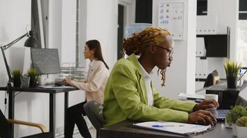 African american businesswoman working on research, analyzing online business statistics on computer. Young entrepreneur using analytics plan to create new investment report at desk. photo