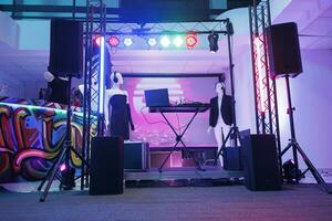 DJ controlador en etapa para discoteca en vacío Club nocturno con No gente. electrónico músico consola equipo, altavoces y focos para En Vivo música concierto en oscuro club. foto