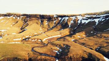 Aerial view of foss a sidu waterfall creating fantastic frozen landscape, icelandic scenery. Beautiful scandinavian cascade running down off of hills, scenic route. Slow motion. photo