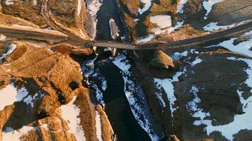Aerial view of nordic canyon with river flow and snowy mountains creating amazing icelandic scenery. Beautiful fjadrargljufur canyon with stream in iceland, natural landscape. Slow motion. photo