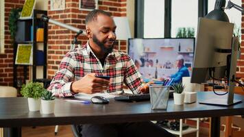 Happy man stoked on doing online shopping, carefully typing credit card information on computer. African american adding payment method on website while in cozy stylish warm home photo