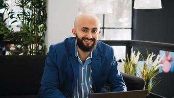 Startup worker uses laptop in open space, reviewing project data on documents at workstation. Executive assistant working on marketing strategy for business development, AI developer. photo