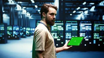 Computer scientist using green screen tablet to verify data center configuration settings. Repairman looking at monitoring software to troubleshoot defective server mainframes root cause photo