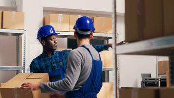 Male manager scanning barcodes on packages in warehouse space, working with scanner and digital tablet to do inventory. Young employee checking stock logistics in industrial department. photo