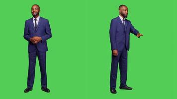 Startup worker talking to people and waving in studio, wearing business suit over full body green screen. Young businessman having conversation on camera, calling someone over. photo