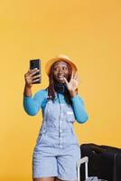 Young woman talking on remote videocall in studio, happy person using online videoconference meeting on vacation trip. Female tourist enjoying teleconference chat and travelling. photo